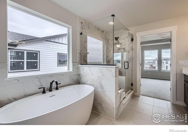 1685 Crystalline Dr, Windsor, CO 80550 - full bathroom with a soaking tub, a marble finish shower, tile patterned flooring, and vanity