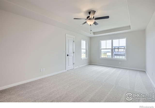 1685 Crystalline Dr, Windsor, CO 80550 - empty room featuring a raised ceiling, light carpet, ceiling fan, and baseboards