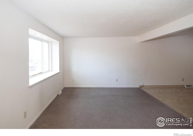 1351 Emery St, Longmont, CO 80501 - carpeted empty room with visible vents, baseboards, and a textured ceiling
