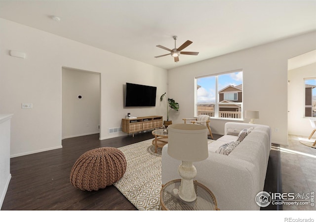 living area with visible vents, baseboards, ceiling fan, and wood finished floors