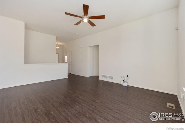 unfurnished room with visible vents, baseboards, dark wood-type flooring, and a ceiling fan