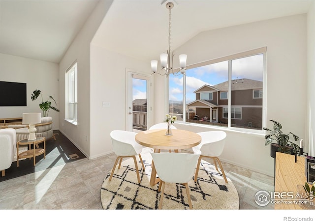 dining room with a healthy amount of sunlight, baseboards, an inviting chandelier, and vaulted ceiling