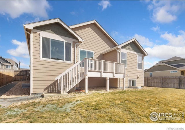 rear view of property featuring a wooden deck, a lawn, a fenced backyard, and stairs