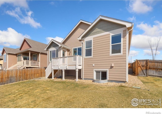 rear view of property with a deck, stairway, a yard, and a fenced backyard