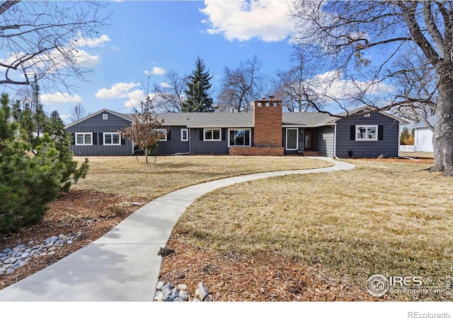 ranch-style house with a chimney and a front lawn