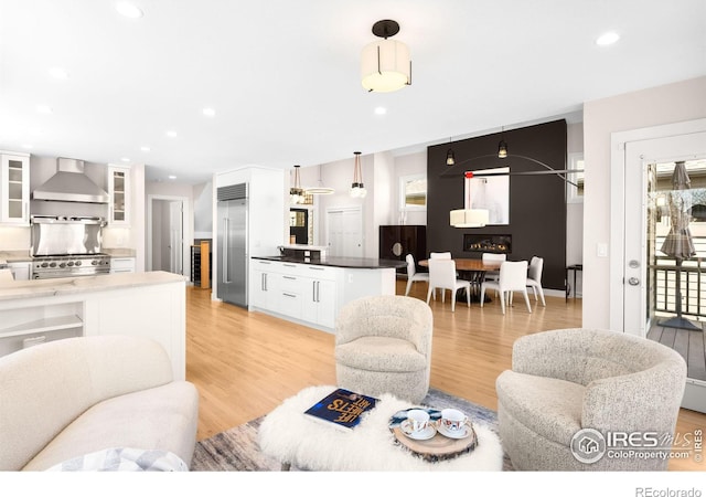 living area featuring recessed lighting, beverage cooler, and light wood finished floors