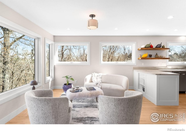 living room featuring recessed lighting, baseboards, and light wood-style flooring