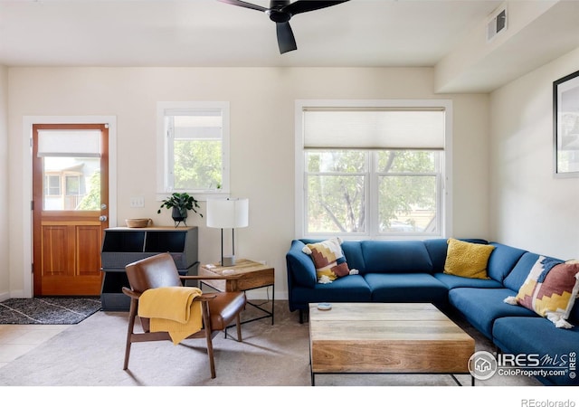 tiled living area featuring a ceiling fan and visible vents