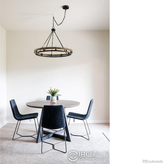 dining room featuring baseboards, light carpet, and a chandelier