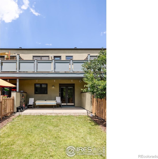 rear view of house featuring stucco siding, fence, french doors, a balcony, and a patio area