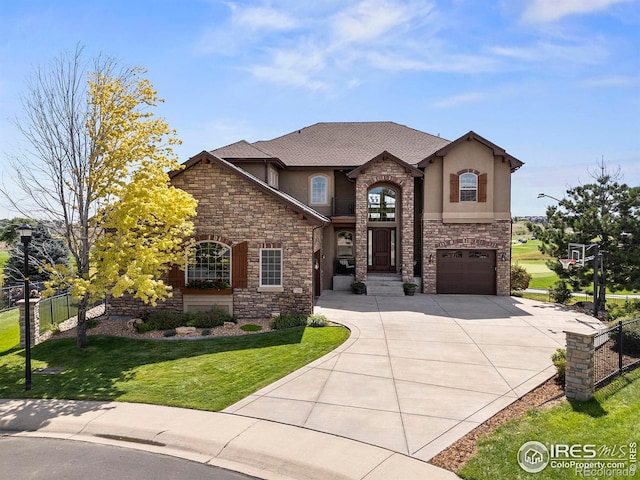 view of front of house with stucco siding, concrete driveway, a front yard, and fence