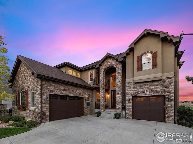 view of front of house featuring stucco siding, concrete driveway, an attached garage, a shingled roof, and a balcony