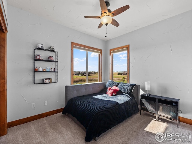 carpeted bedroom featuring baseboards and ceiling fan