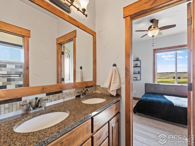 bathroom with a sink, decorative backsplash, a ceiling fan, and double vanity