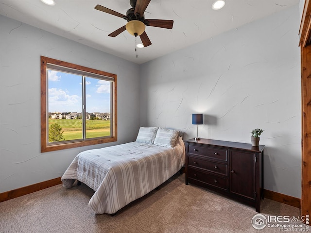 bedroom featuring a ceiling fan, light colored carpet, and baseboards