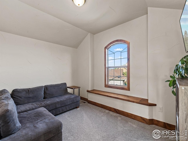 carpeted living room with baseboards and lofted ceiling