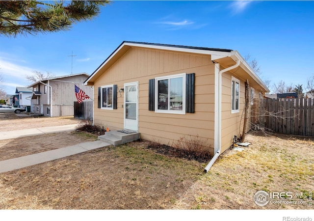 bungalow-style home with fence