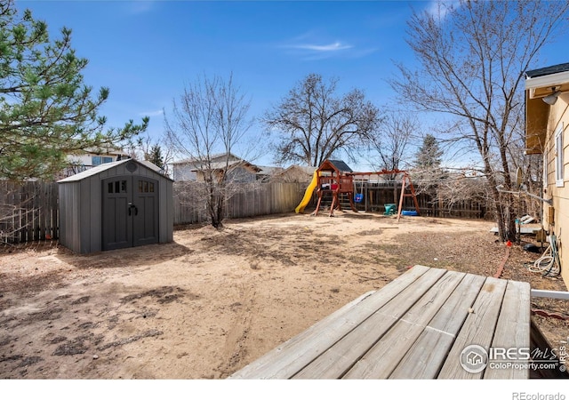 view of yard featuring an outbuilding, a shed, a playground, and a fenced backyard