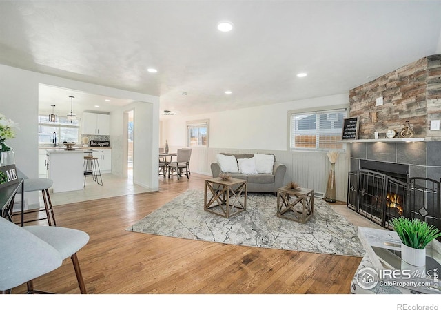 living room with recessed lighting, light wood-style floors, and a fireplace