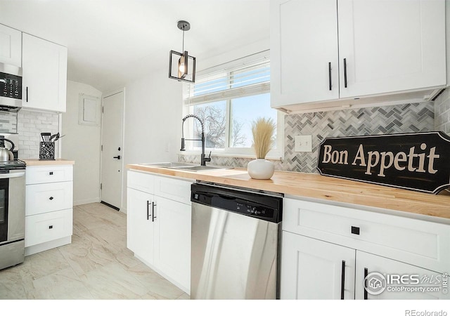 kitchen featuring a sink, white cabinets, appliances with stainless steel finishes, wood counters, and marble finish floor