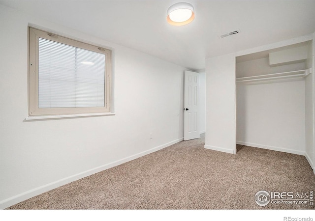 unfurnished bedroom featuring visible vents, baseboards, carpet, and a closet