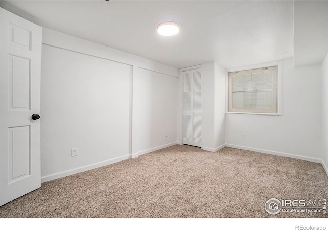 spare room with baseboards and carpet