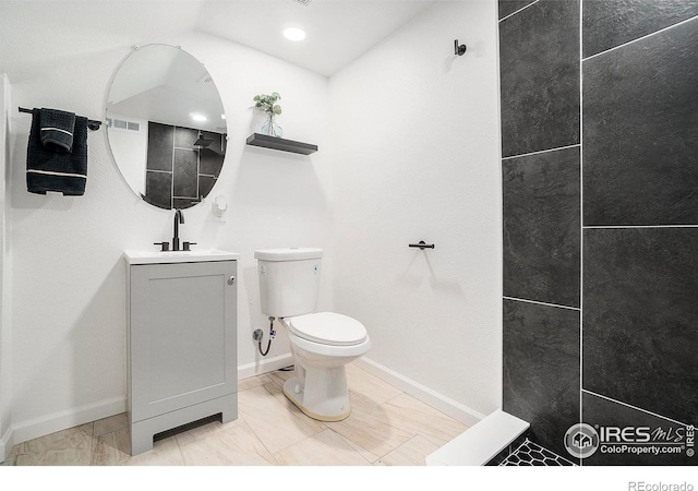 bathroom featuring visible vents, baseboards, toilet, and vanity