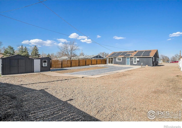 view of yard featuring a storage shed, an outdoor structure, and fence