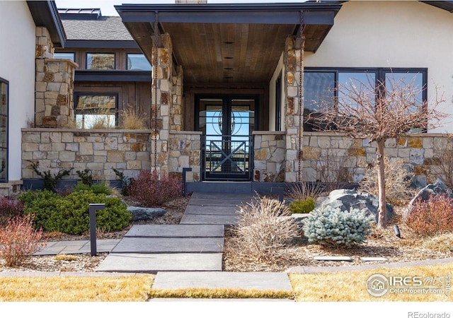 property entrance featuring stucco siding and stone siding