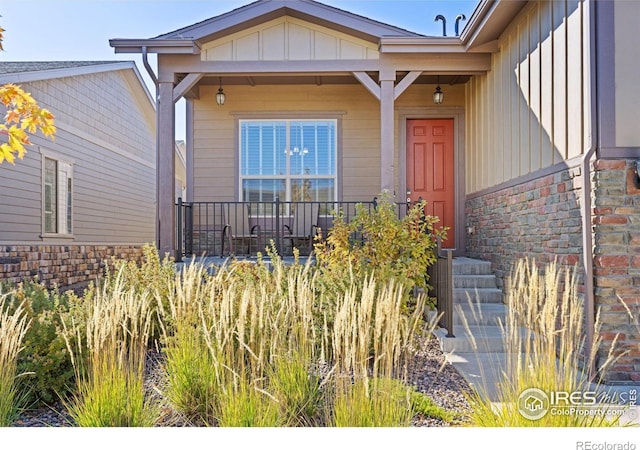 doorway to property featuring covered porch and board and batten siding