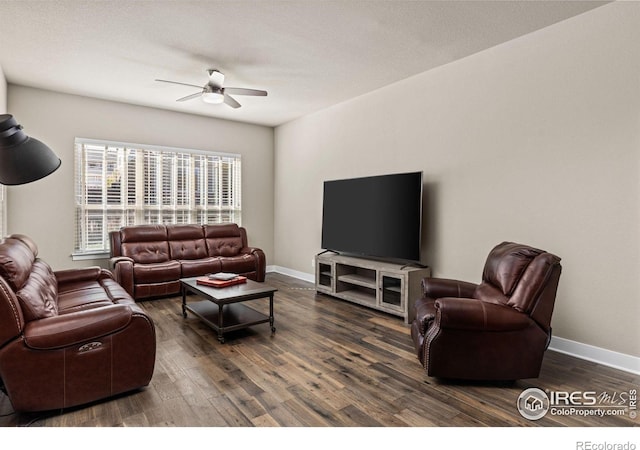 living room featuring ceiling fan, baseboards, and wood finished floors