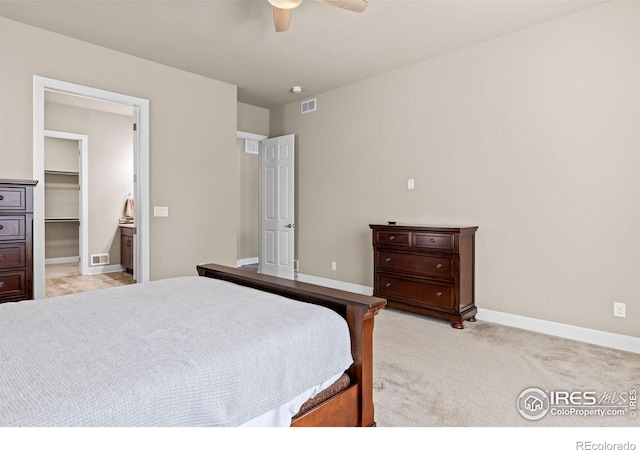 bedroom with baseboards, visible vents, ceiling fan, a spacious closet, and light carpet