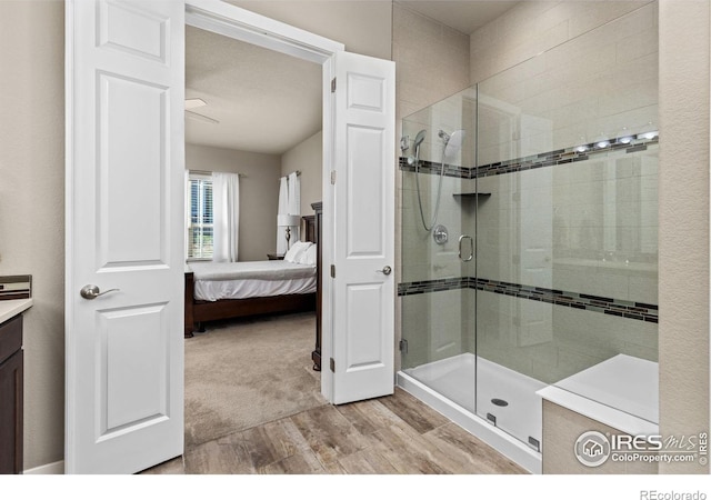 ensuite bathroom with ensuite bathroom, vanity, wood finished floors, and a shower stall