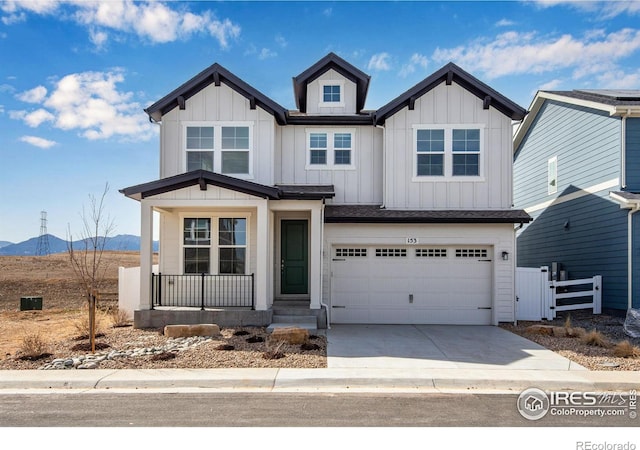 view of front of home with concrete driveway, a mountain view, an attached garage, and board and batten siding