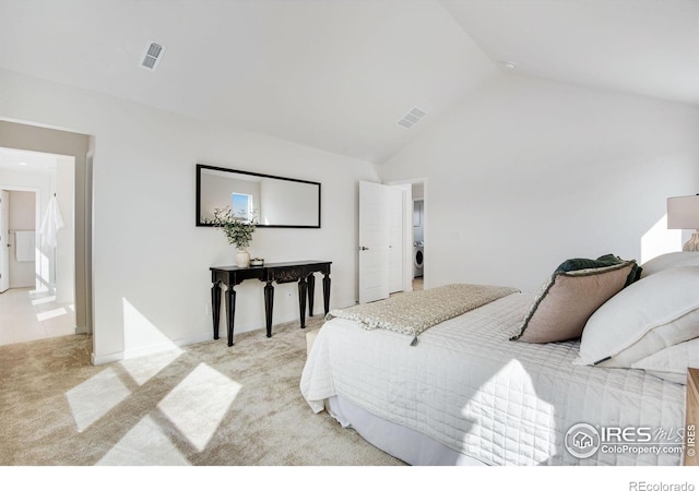 bedroom featuring visible vents, light colored carpet, washer / clothes dryer, and high vaulted ceiling