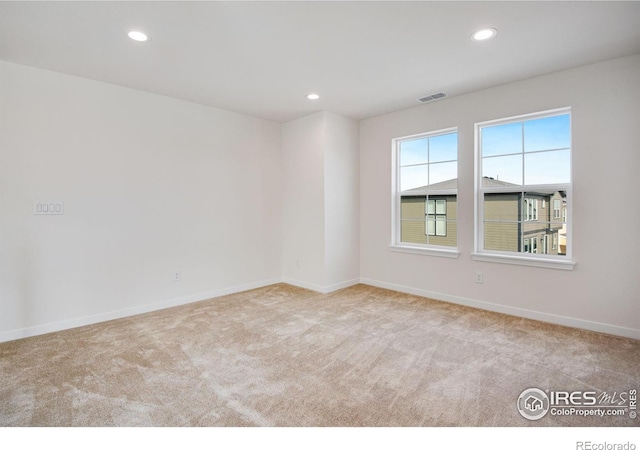 unfurnished room with recessed lighting, visible vents, carpet floors, and baseboards