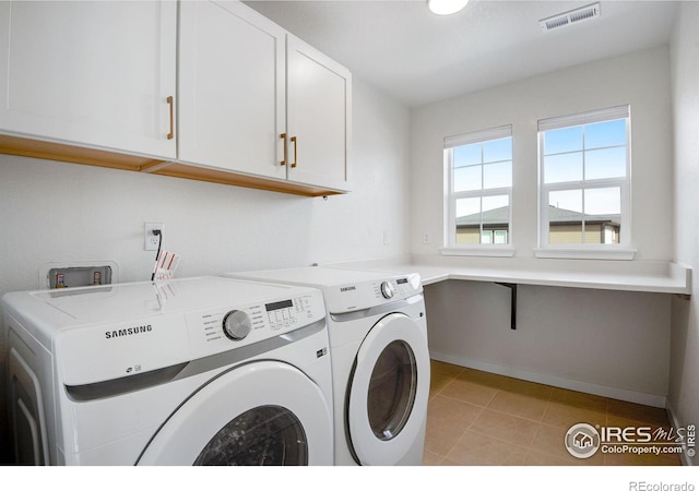 laundry room with washer and clothes dryer, visible vents, cabinet space, and light tile patterned floors