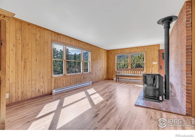 15 Golden Age Rd, Jamestown, CO 80455 - unfurnished living room featuring a wood stove, a baseboard heating unit, wood finished floors, and wood walls