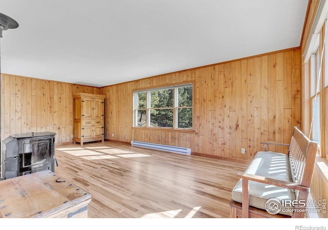 15 Golden Age Rd, Jamestown, CO 80455 - unfurnished living room with baseboard heating, a wood stove, wood walls, and light wood finished floors