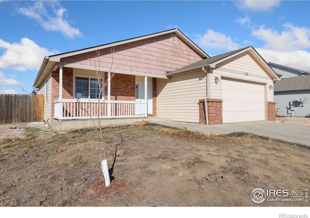 single story home with driveway, fence, covered porch, a garage, and brick siding