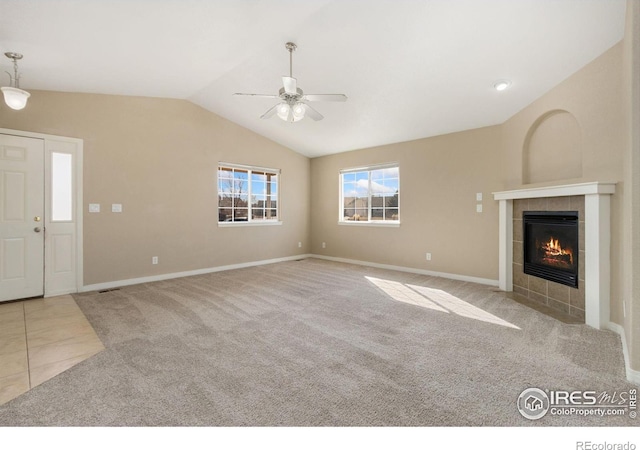 unfurnished living room featuring tile patterned floors, carpet floors, a fireplace, ceiling fan, and vaulted ceiling