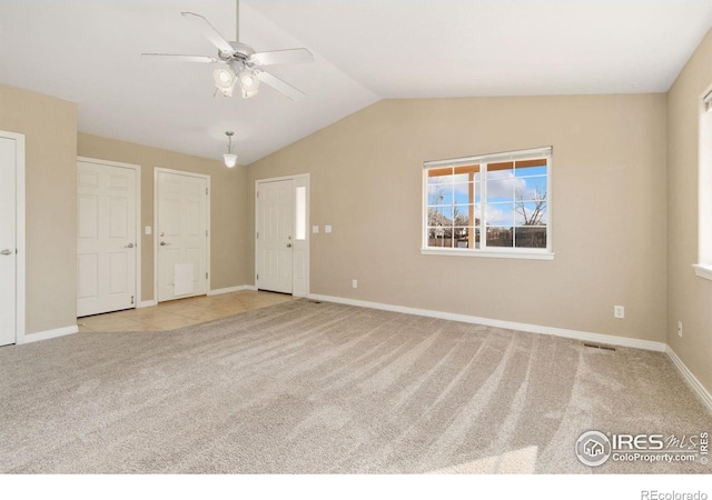 interior space featuring carpet flooring, a ceiling fan, baseboards, and vaulted ceiling