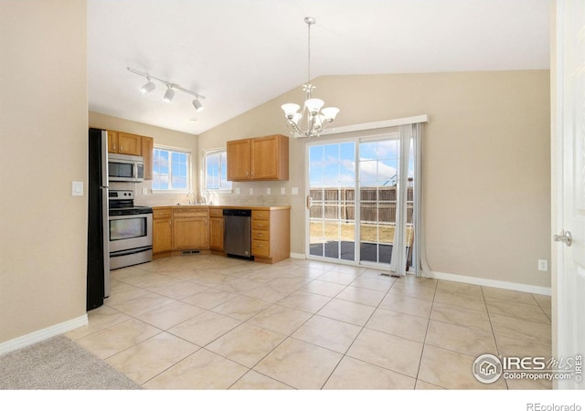 kitchen featuring lofted ceiling, a wealth of natural light, appliances with stainless steel finishes, and a sink