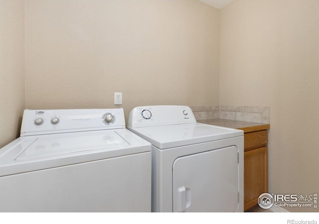 washroom featuring washer and dryer and cabinet space