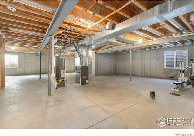 unfinished basement featuring heating unit and water heater