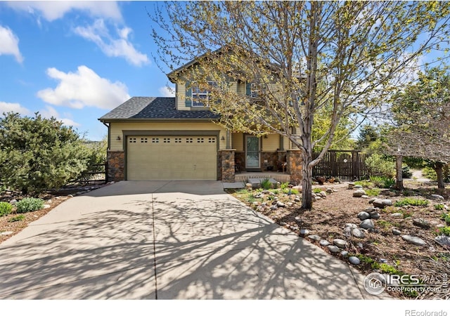 view of front of house with a porch, driveway, roof with shingles, fence, and stone siding
