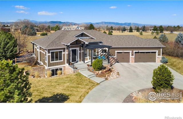 craftsman-style home featuring a mountain view, an attached garage, concrete driveway, and a front lawn