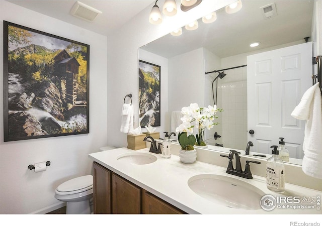 full bathroom with double vanity, toilet, visible vents, and a sink