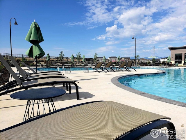 pool with a patio area and fence