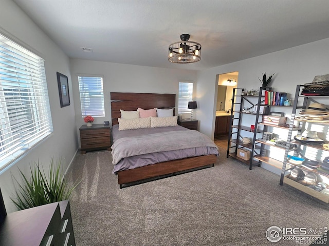 bedroom with visible vents, connected bathroom, and carpet